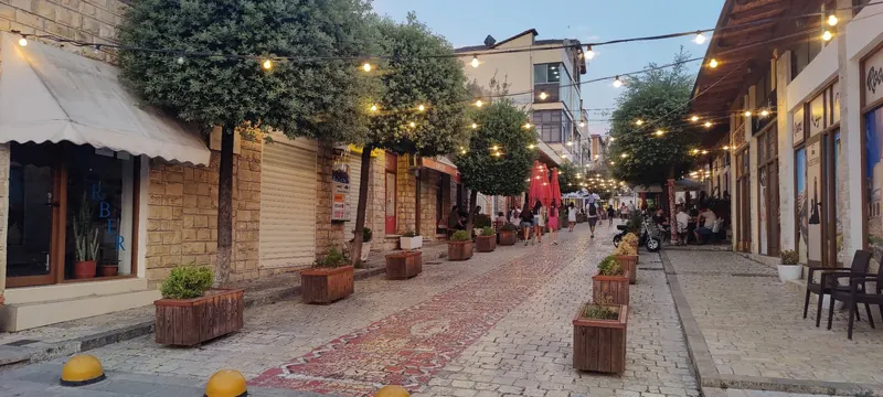 The old bazaar of Krujë at dusk: cobbles, planters and string lights